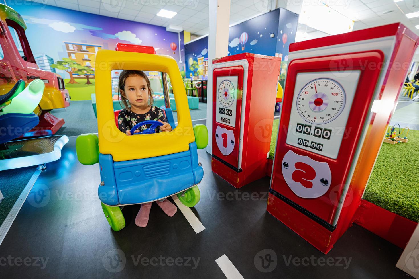 brincando no playground do play center interno, garota no posto de gasolina de carro de brinquedo. foto