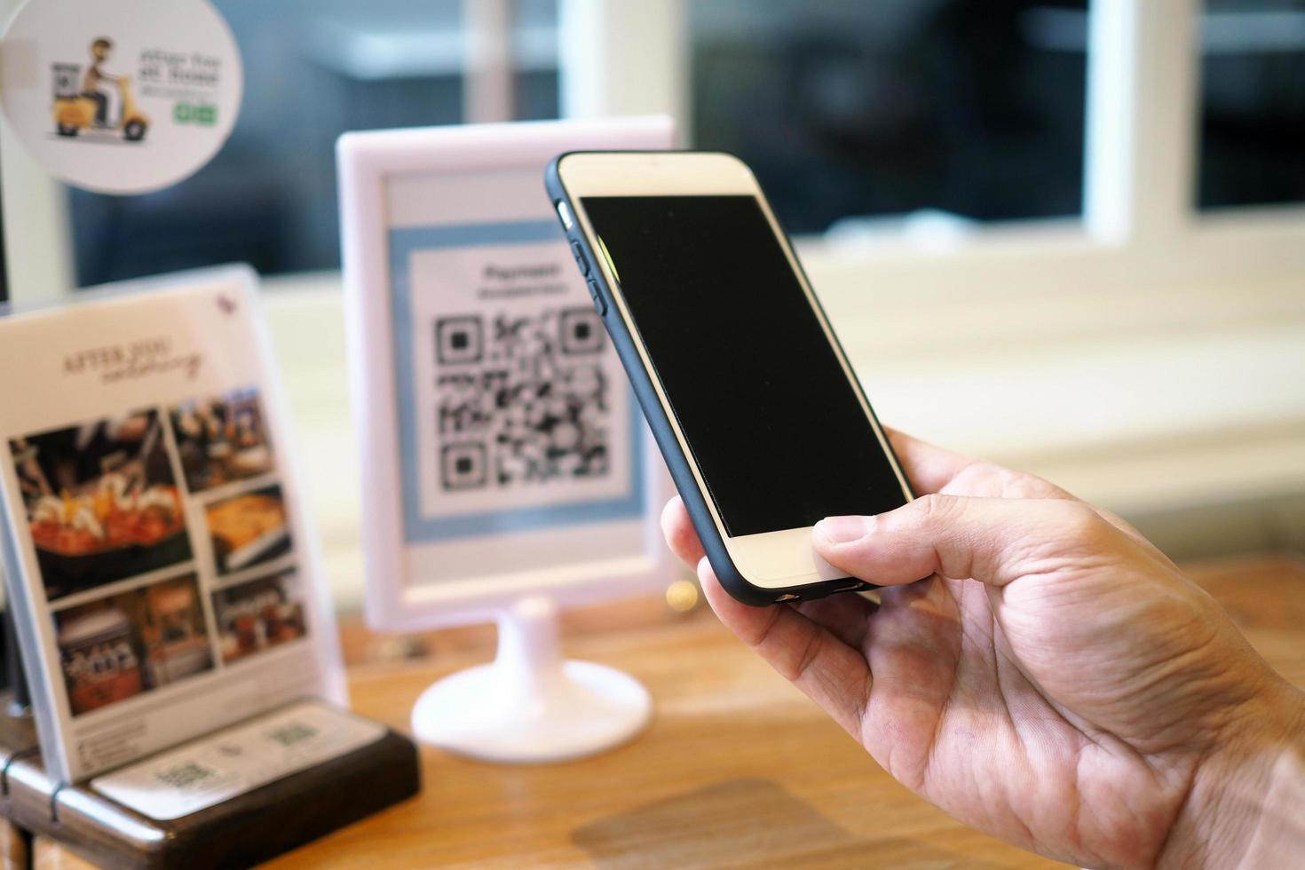 mão, use o telefone para digitalizar o código de barras para obter o desconto na cafeteria foto