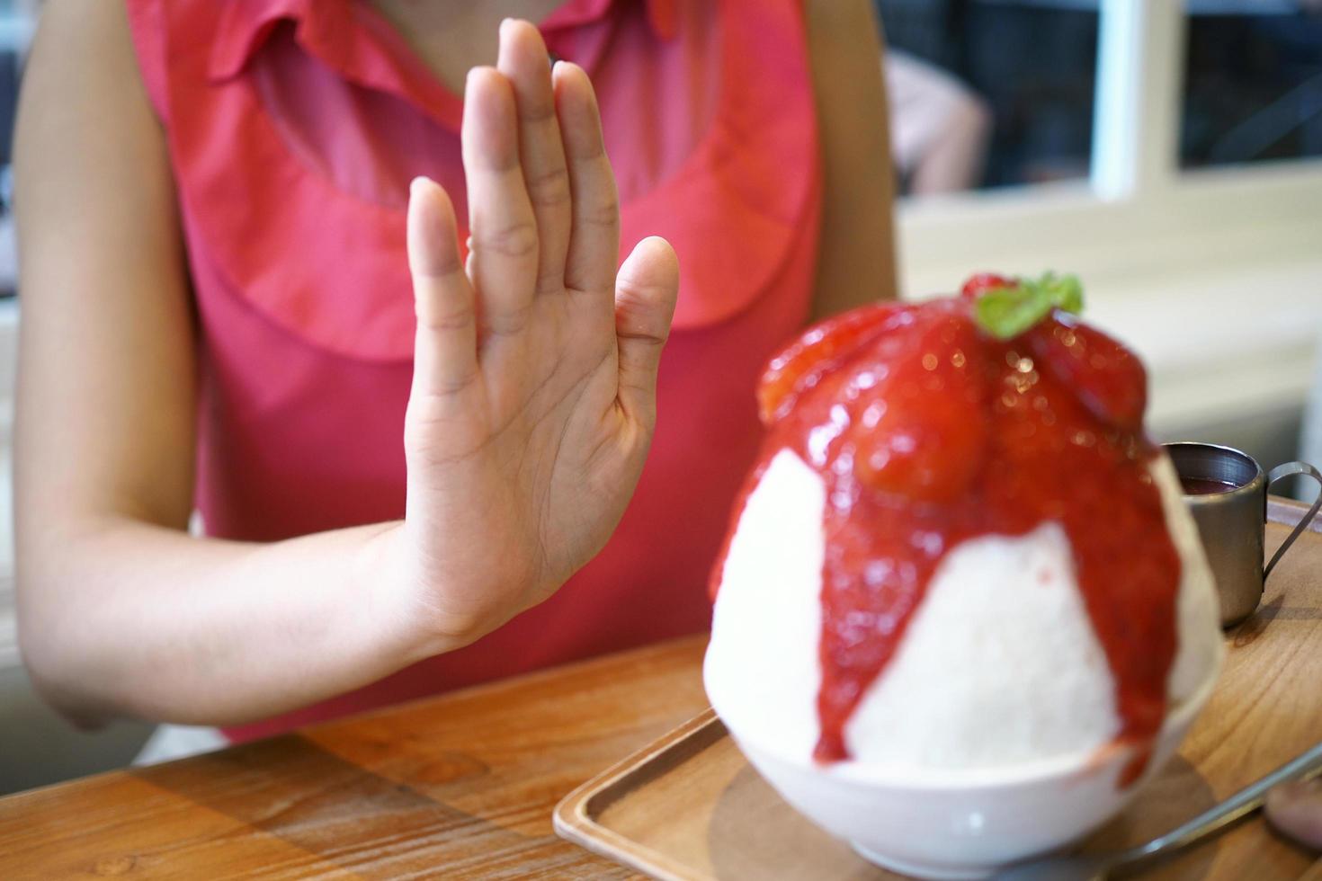 as mulheres empurram o copo de sorvete. recusou-se a comer todos os tipos de doces. evite açúcar e doces para uma boa saúde. conceito de dieta foto