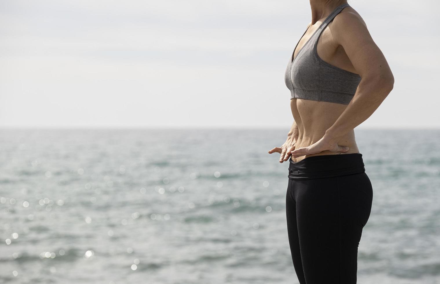 mulher fazendo exercícios hipopressivos no mar foto