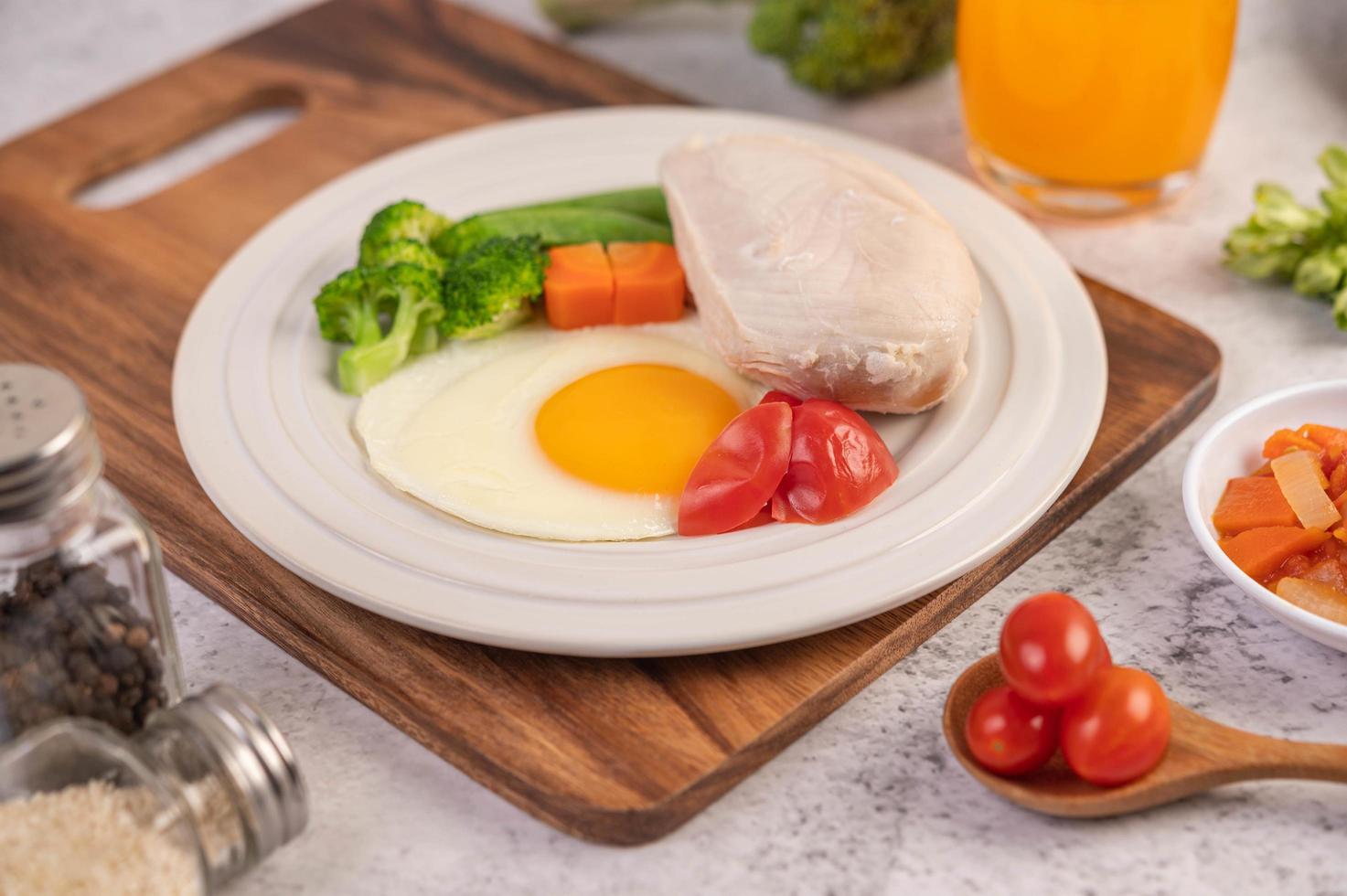 café da manhã com frango, ovos fritos, brócolis, cenoura, tomate e alface foto