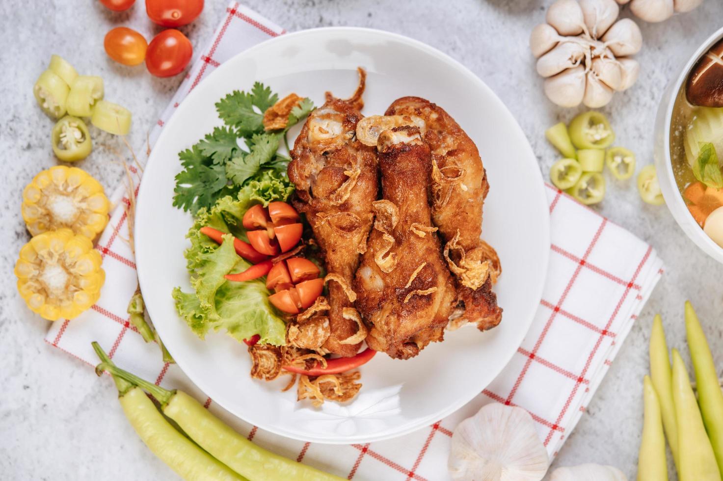 pernas de frango frito com tomate, pimenta, cebola frita, alface, milho e cogumelo foto