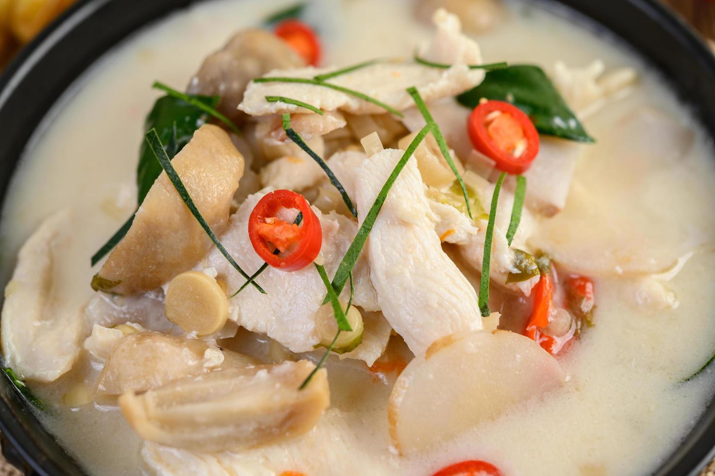 sopa tom kha kai com folhas de limão kaffir, capim-limão, cebola roxa, galanga e pimenta foto