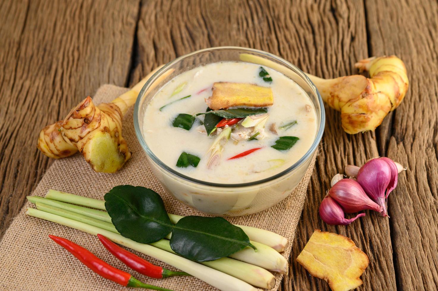 tom kha kai, sopa de coco tailandesa na mesa de madeira da cozinha foto