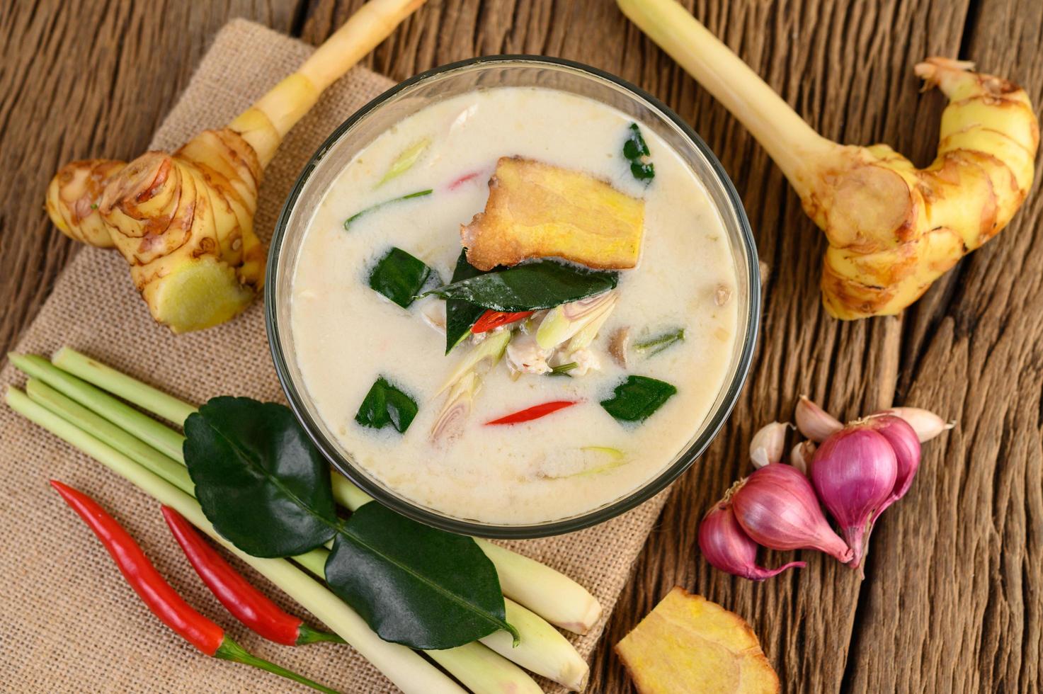 tom kha kai, sopa de coco tailandesa na mesa de madeira da cozinha foto