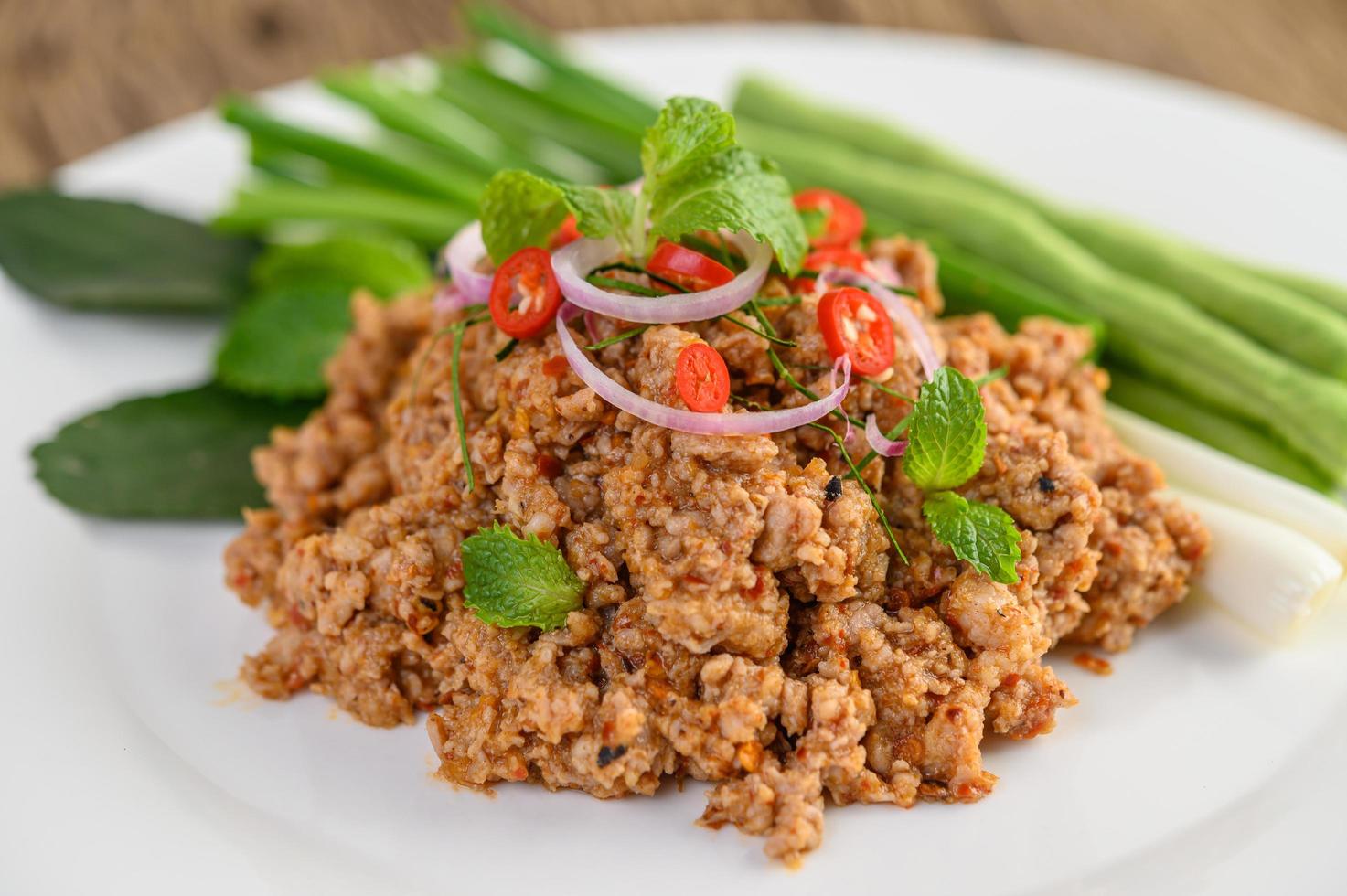 salada picante de porco picada com vegetais verdes foto