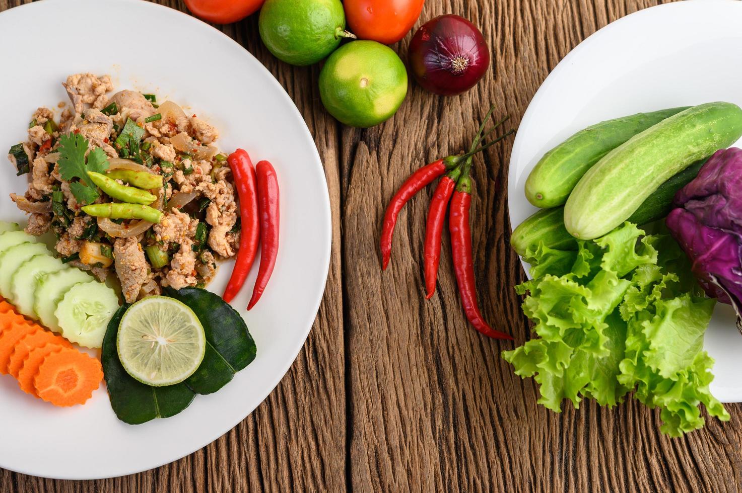 Salada de porco picada com especiarias em uma mesa de madeira foto