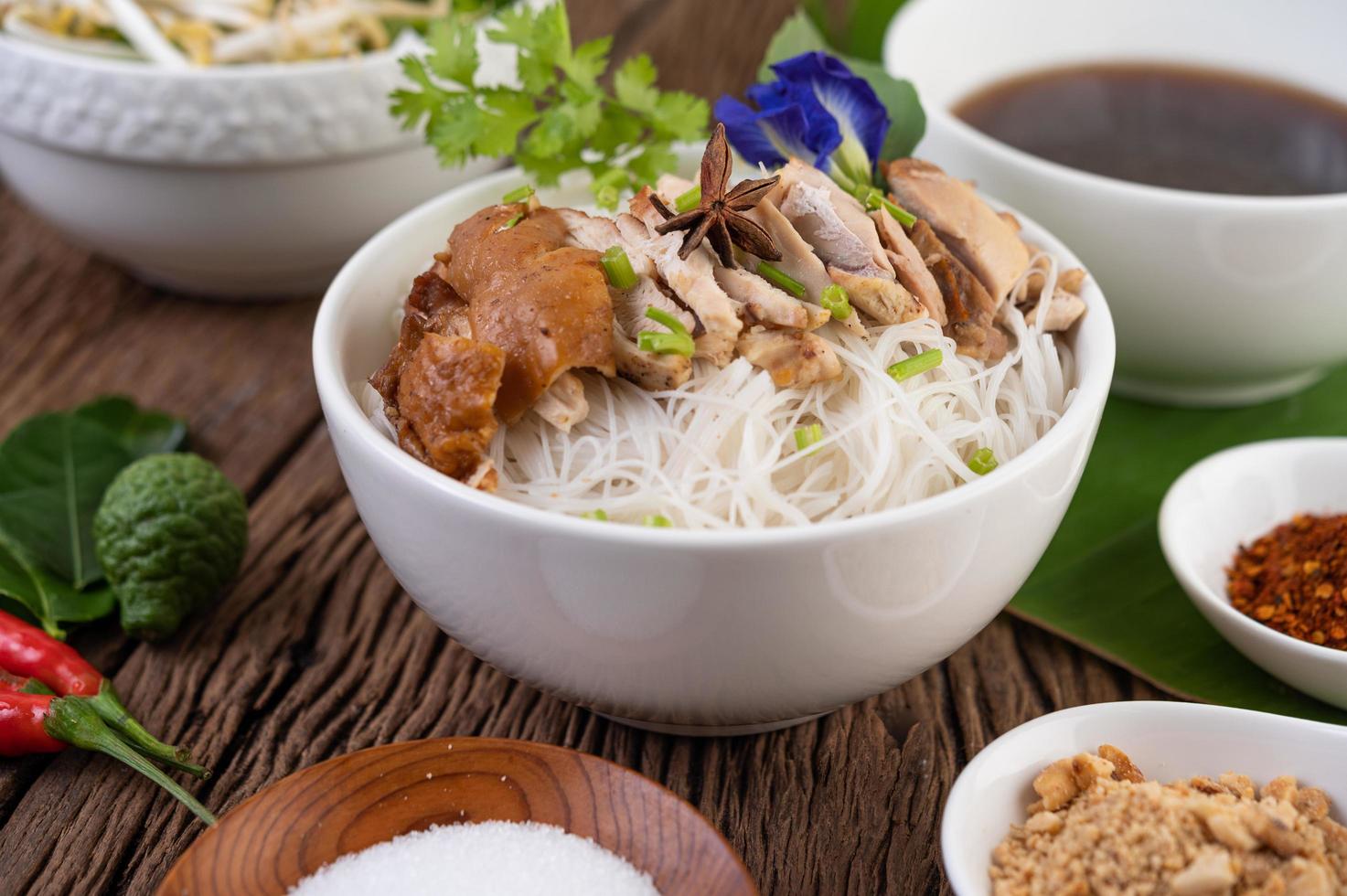 frango e macarrão em uma tigela com acompanhamentos foto