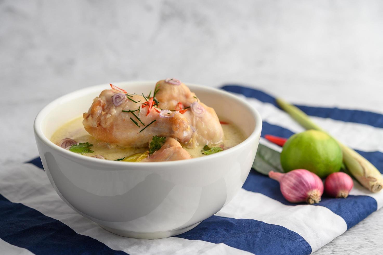 tom kha kai, sopa de coco tailandesa em um pano listrado de azul foto