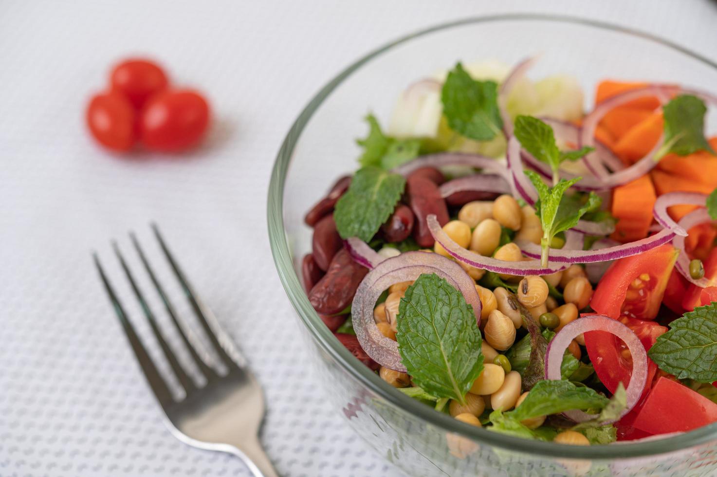 salada de frutas e vegetais frescos em uma tigela de vidro foto