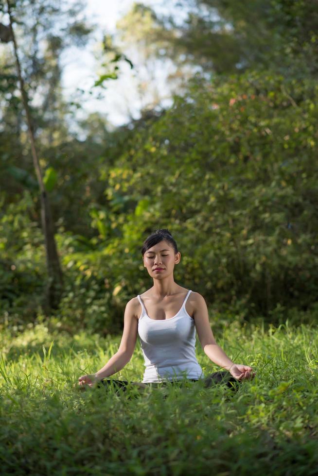 mulher em pose de ioga ao ar livre na natureza foto