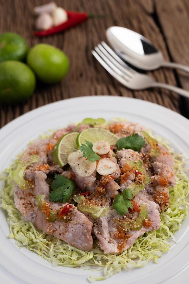 Salada picante de lima e porco com galanga, pimenta e tomate foto