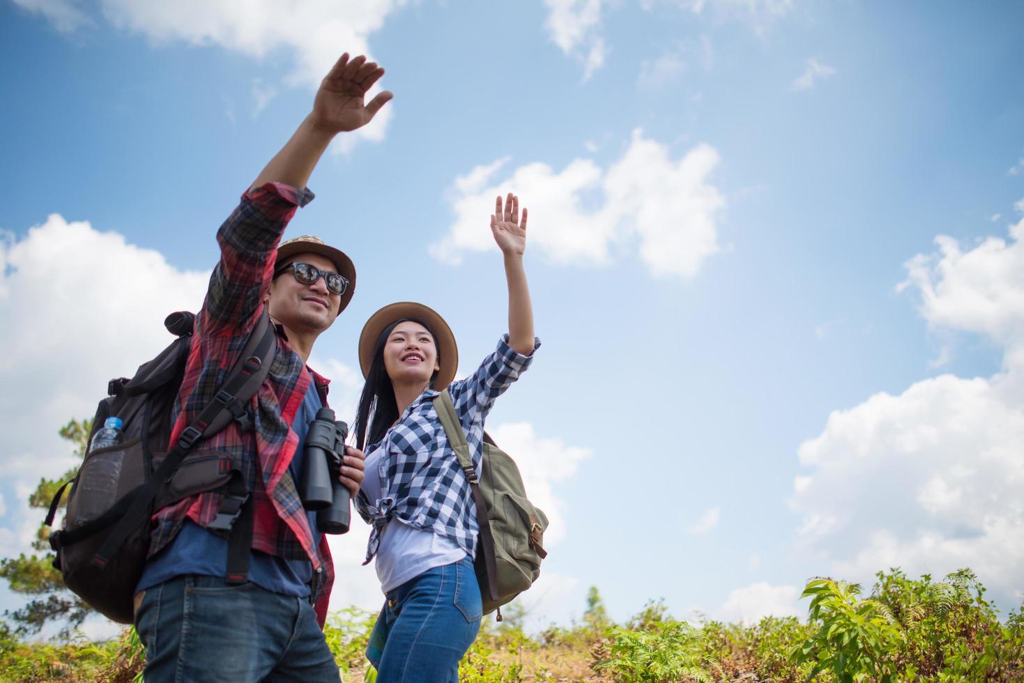 jovem casal caminhando com mochilas na floresta foto