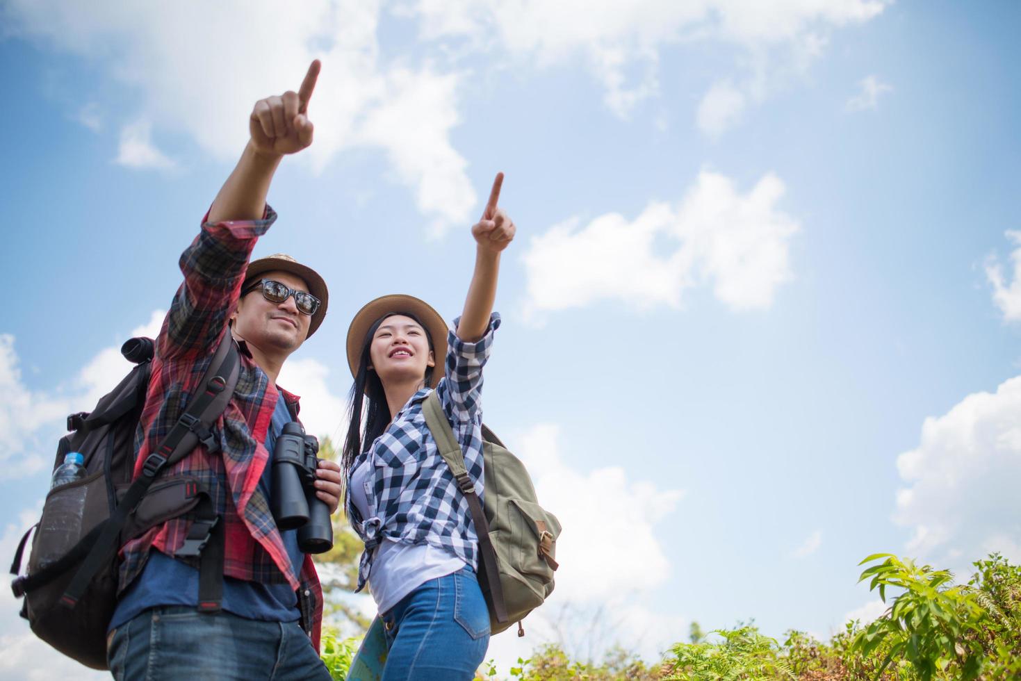 jovem casal caminhando com mochilas na floresta foto