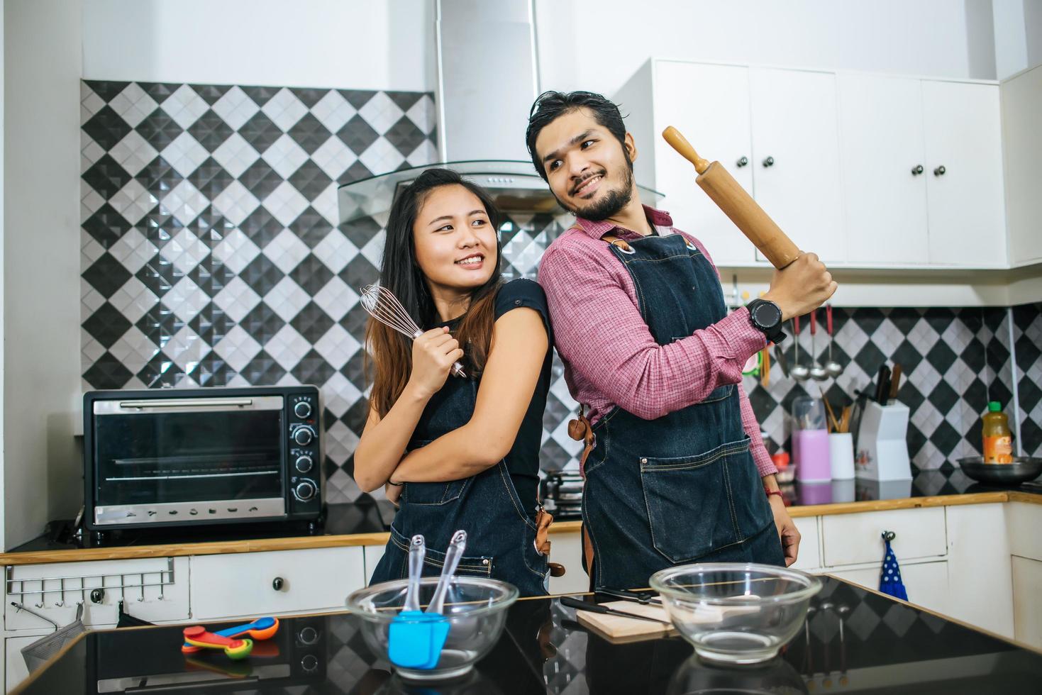 casal atraente cozinhando na cozinha de casa foto