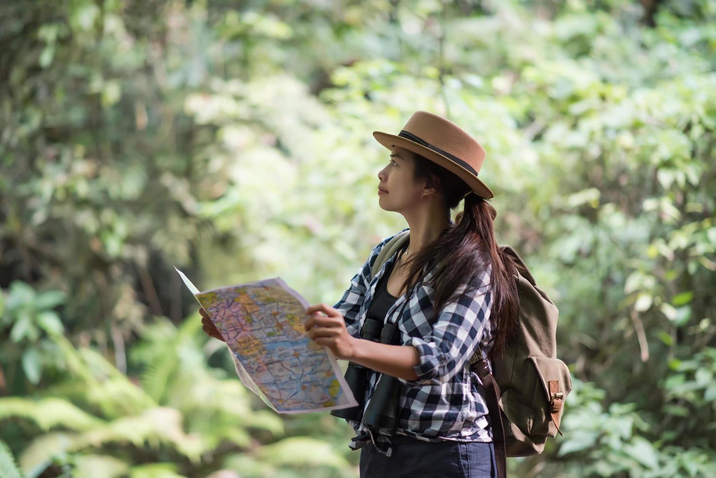 jovem feliz e aventureira observando a vida selvagem com binóculos na natureza foto