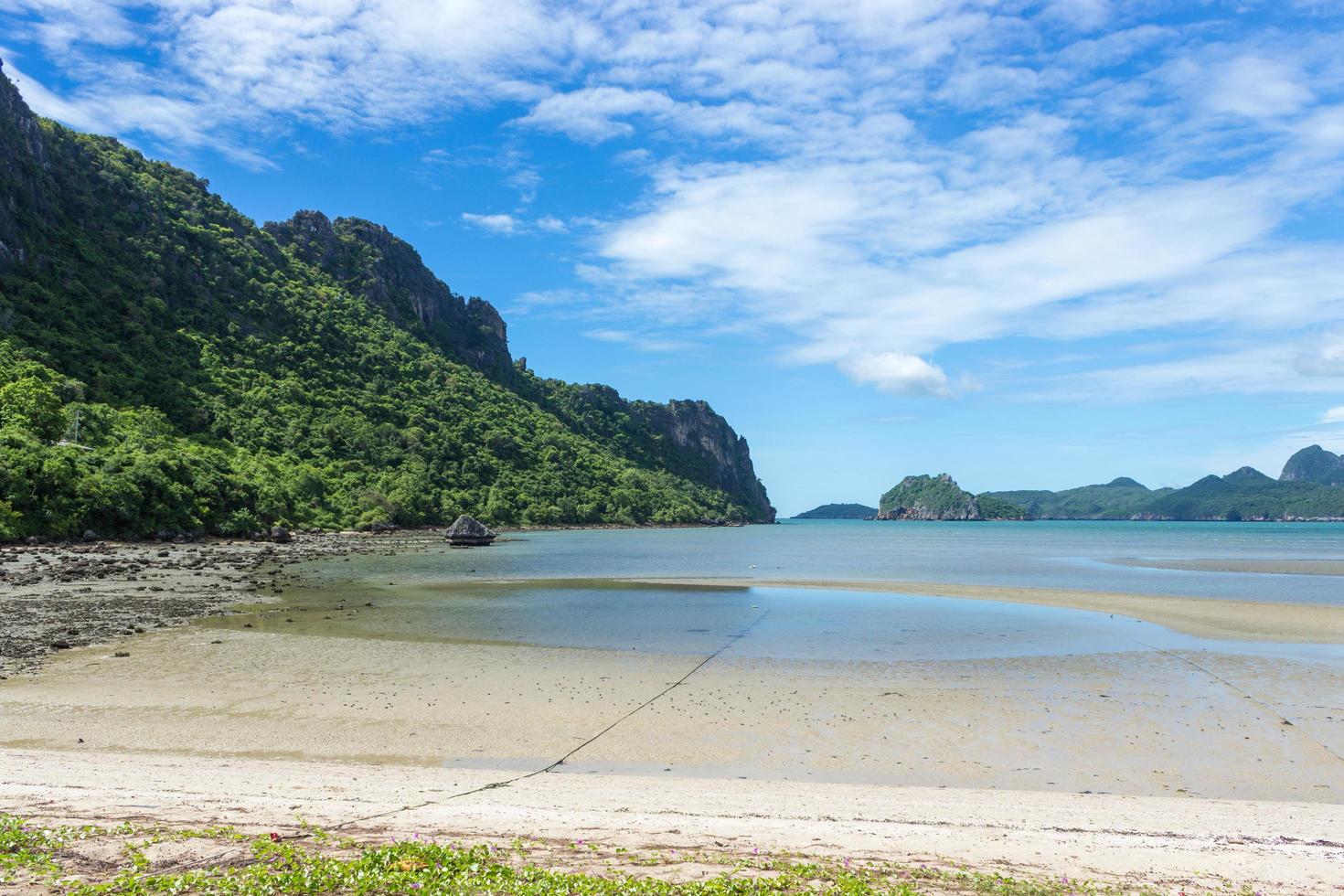 praia e montanhas contra céu azul nublado foto