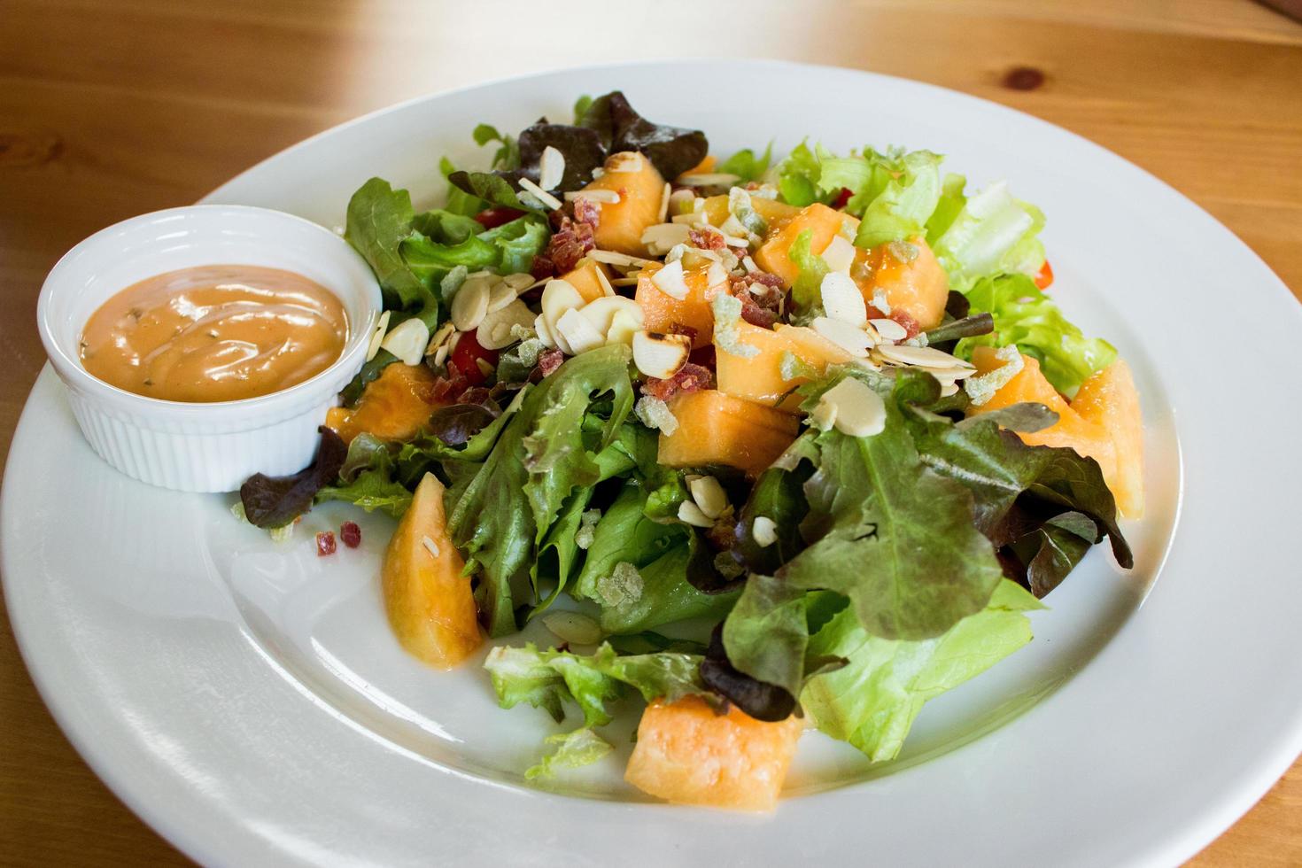 salada e molho no prato branco foto