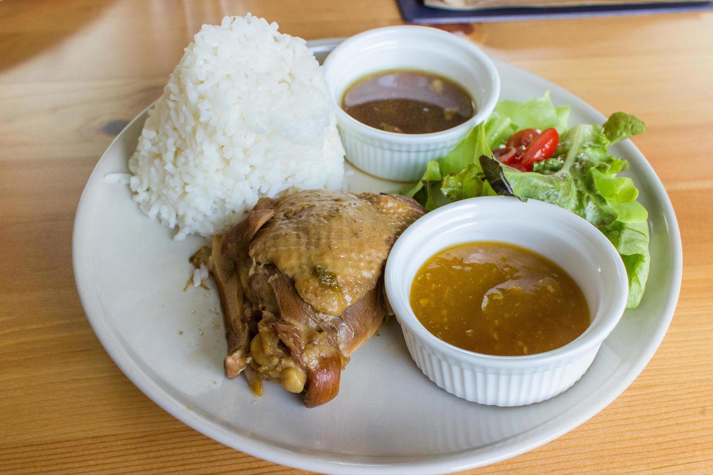 frango estufado com arroz e salada no prato branco foto