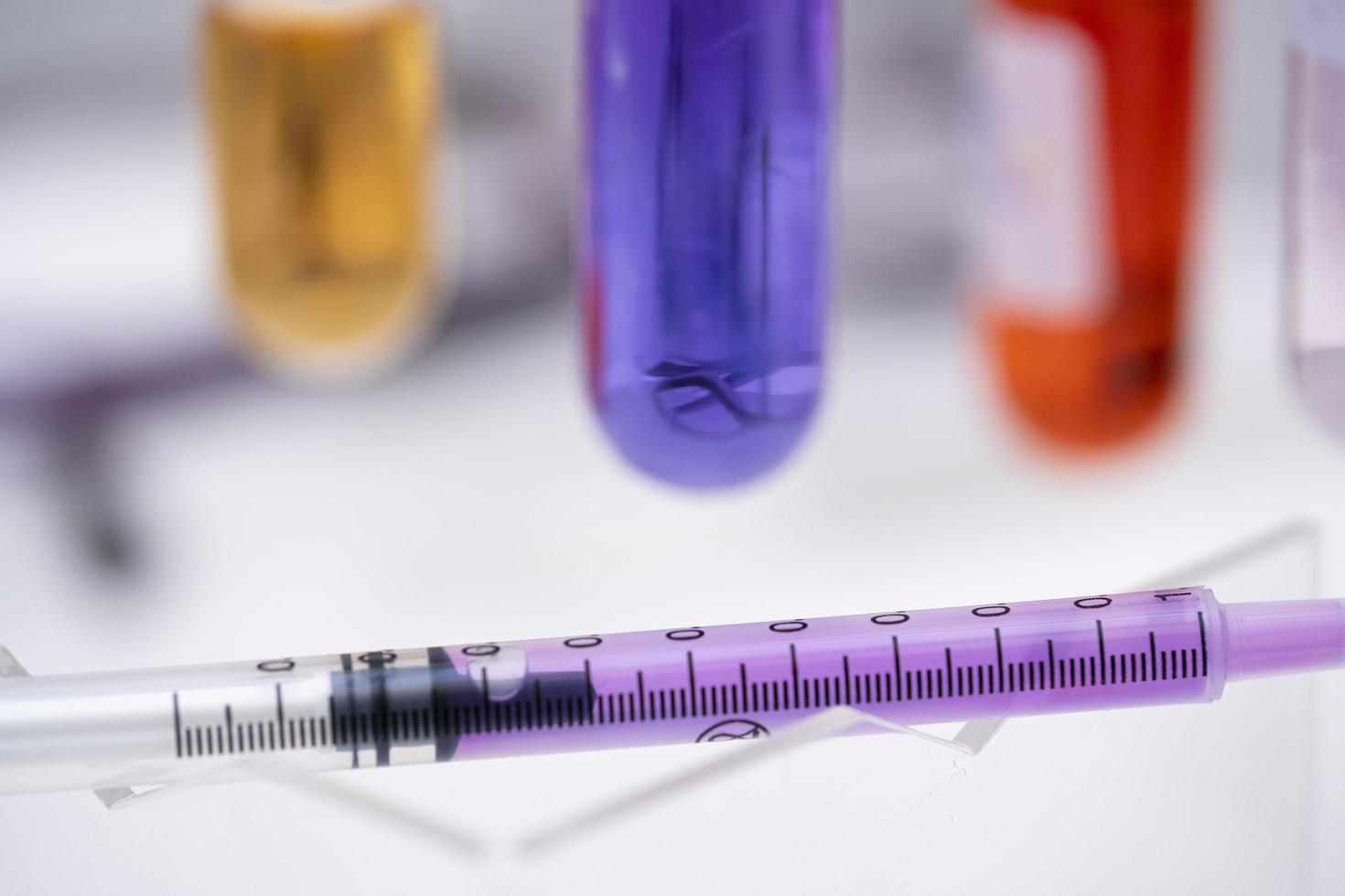 seringa, kit de vacinação de plástico com vacina covid-19, tubos de ensaio de fundo com amostras foto