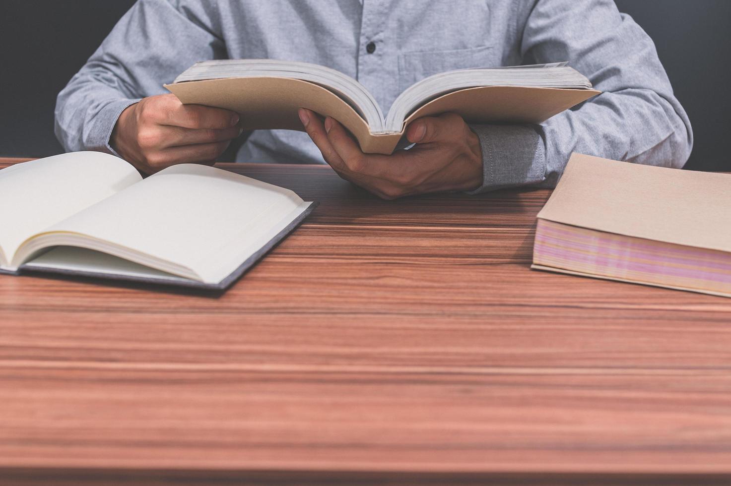 homem lendo um livro em sua mesa foto