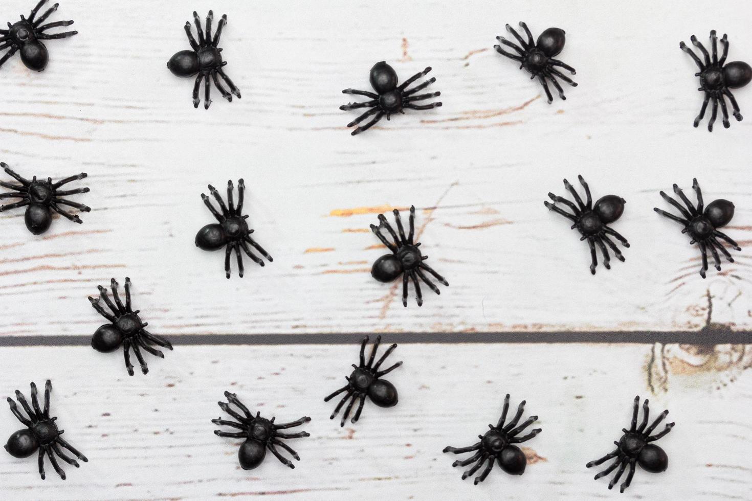 brinquedos de aranhas de plástico em um fundo de madeira. foto