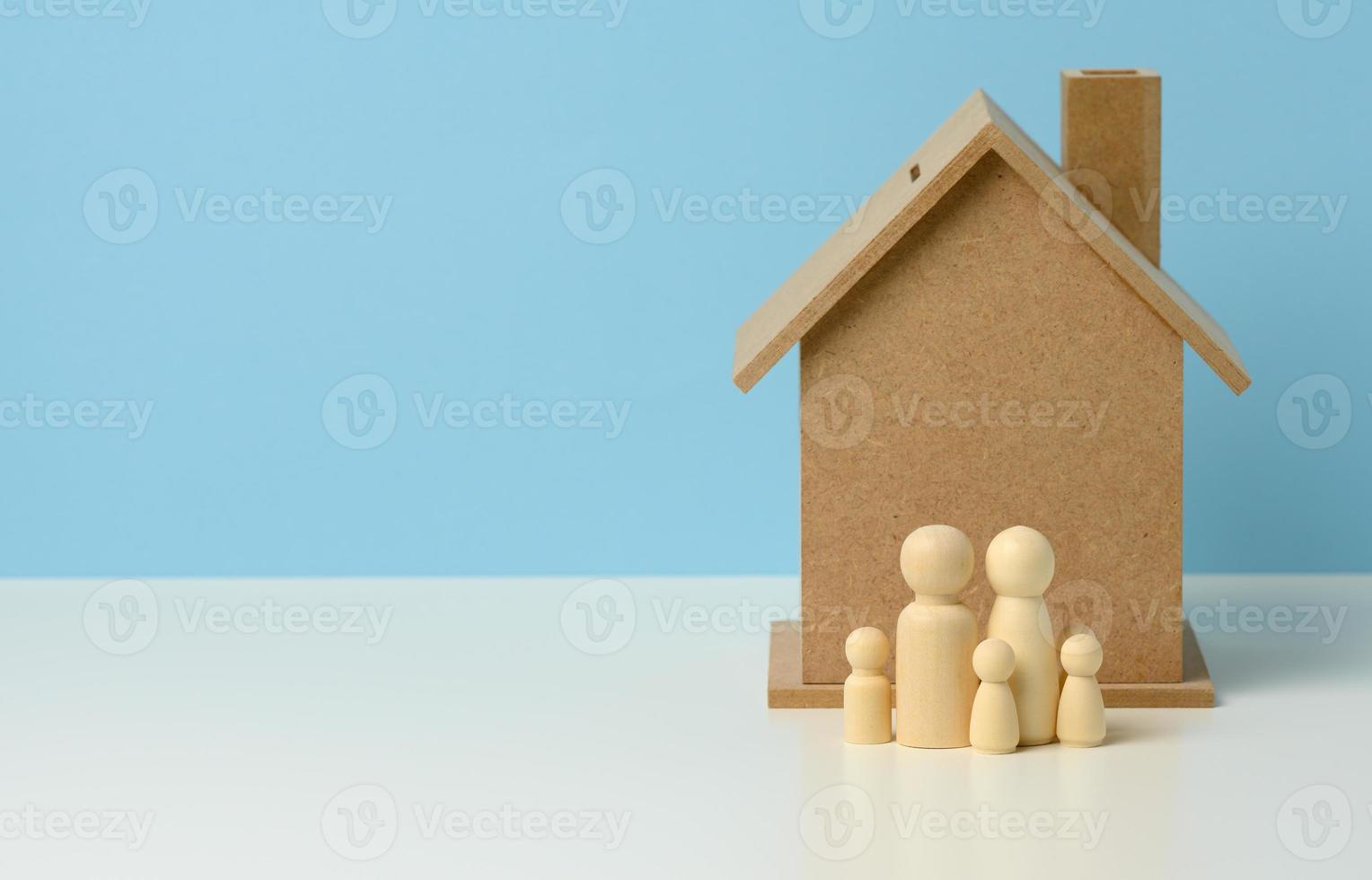 estatuetas de família de madeira, casa modelo. compra de imóveis, conceito de aluguel. mudança para novos apartamentos foto