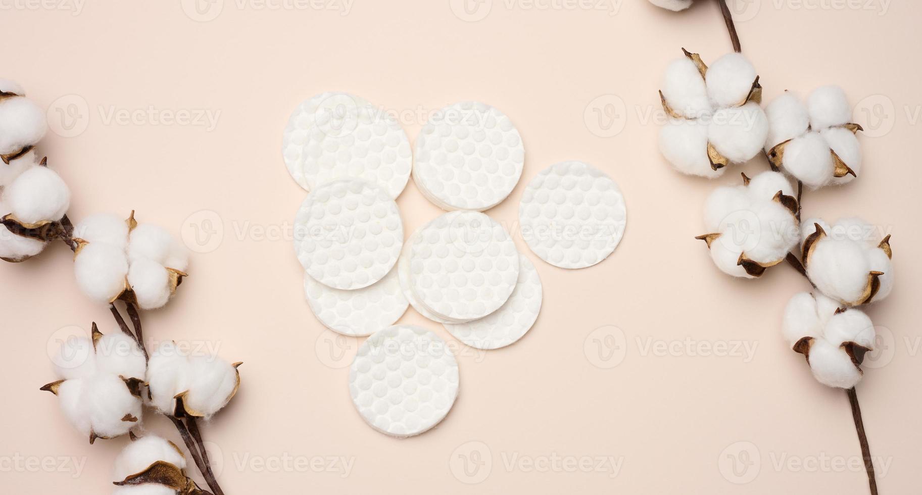 esponjas de algodão branco sobre fundo bege. design para a indústria da beleza, medicina e cosmética foto