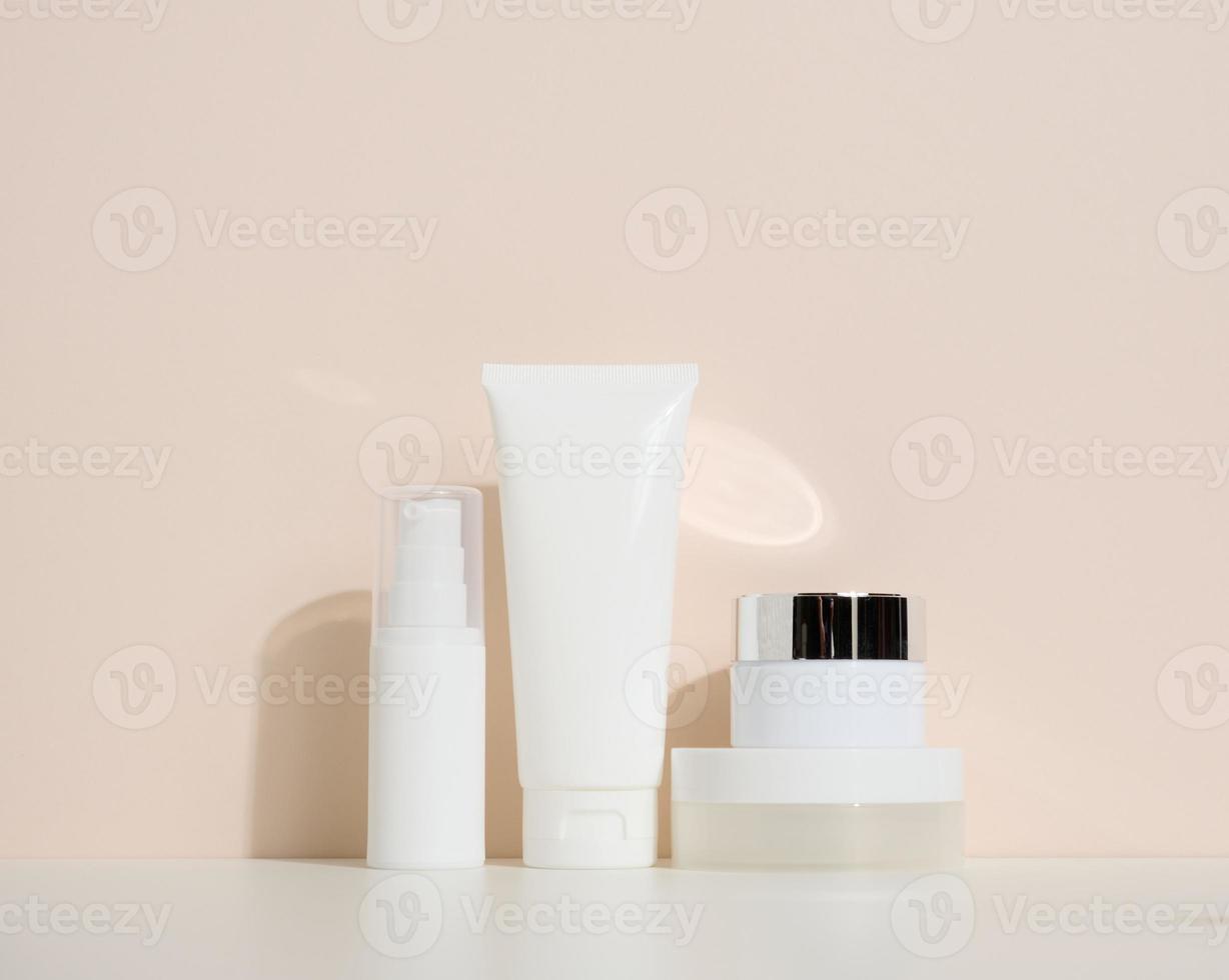 frasco, garrafa e tubos de plástico brancos vazios para cosméticos em um fundo bege. embalagem para creme, gel, soro, publicidade e promoção de produtos, mock up foto