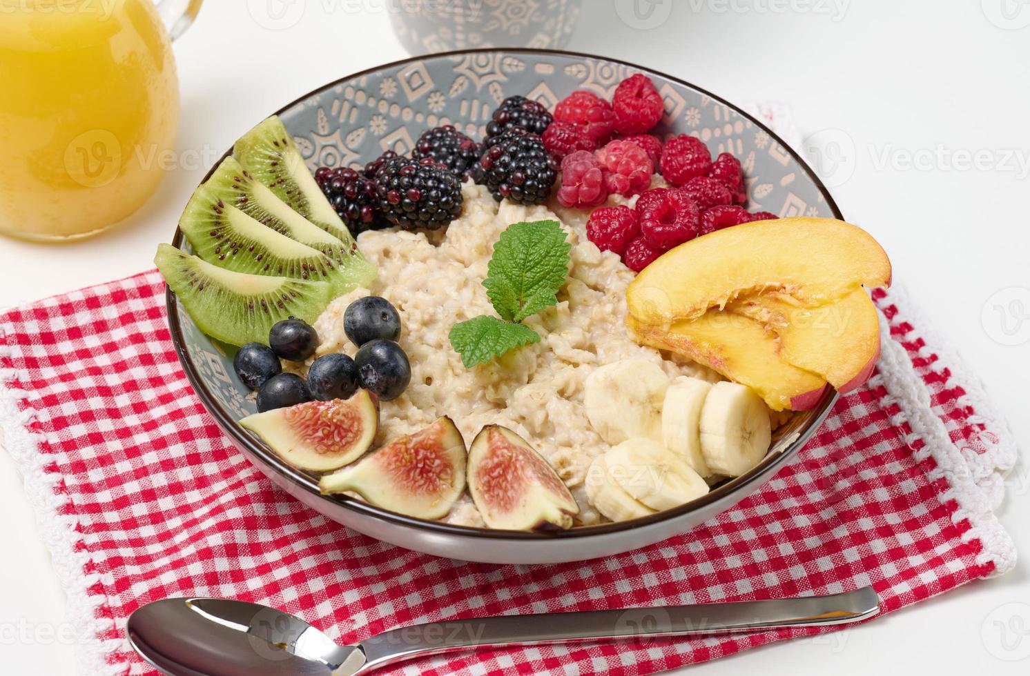 aveia cozida com frutas em um prato redondo sobre uma mesa branca, café da manhã saudável. vista de cima foto