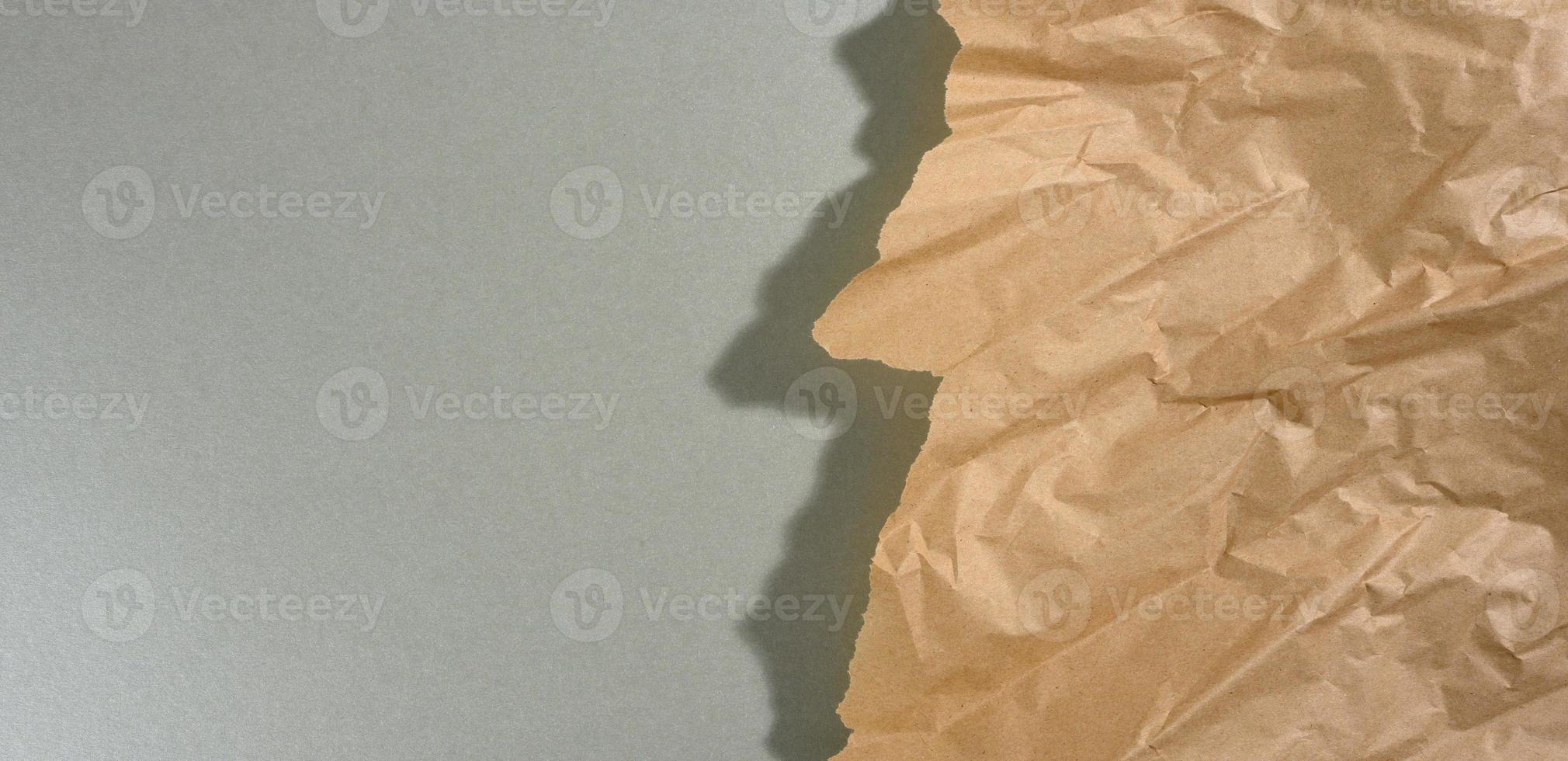 pedaço de papel marrom menta com bordas rasgadas e sombra no fundo cinza. pano de fundo criativo abstrato para designer foto