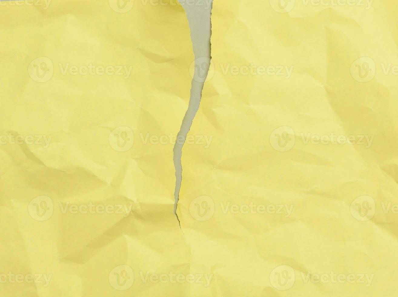 folha de papel amarela amassada rasgada em branco sobre um fundo cinza foto