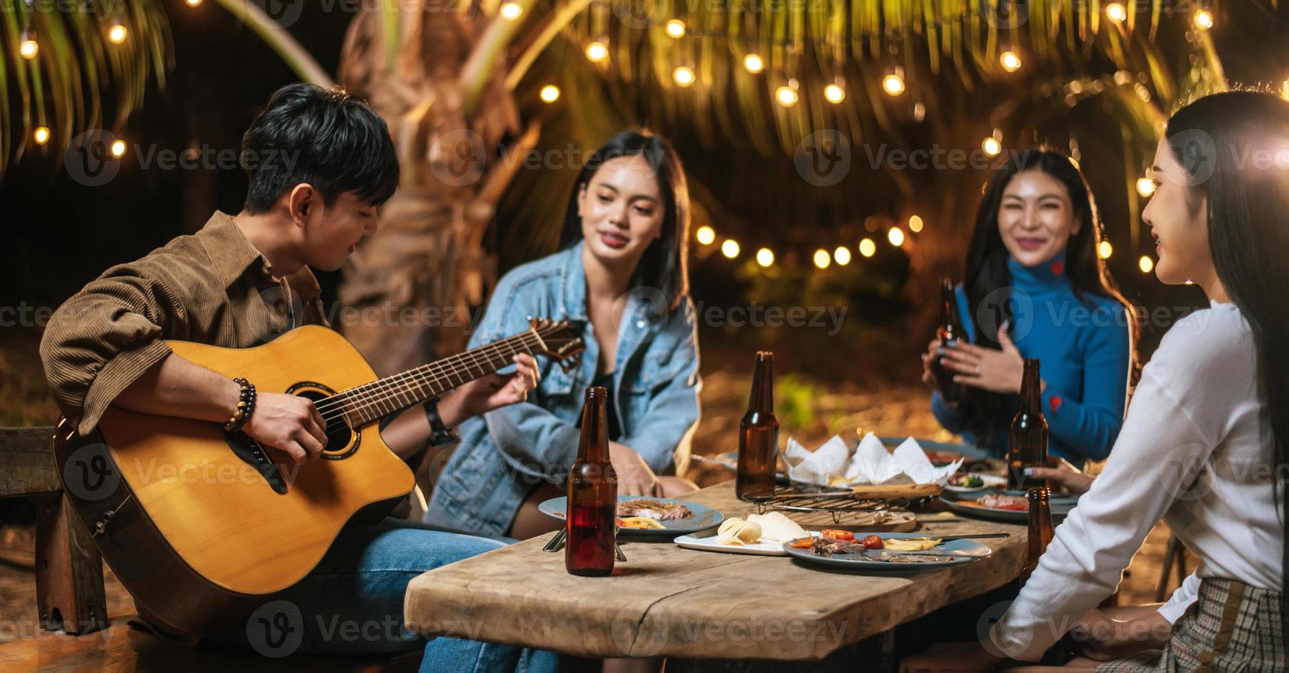 retrato de grupo asiático feliz de amigos se divertindo com música jantando e bebendo juntos ao ar livre - grupo de amigos felizes brindando cervejas - pessoas, comida, estilo de vida de bebida, conceito de celebração de ano novo. foto