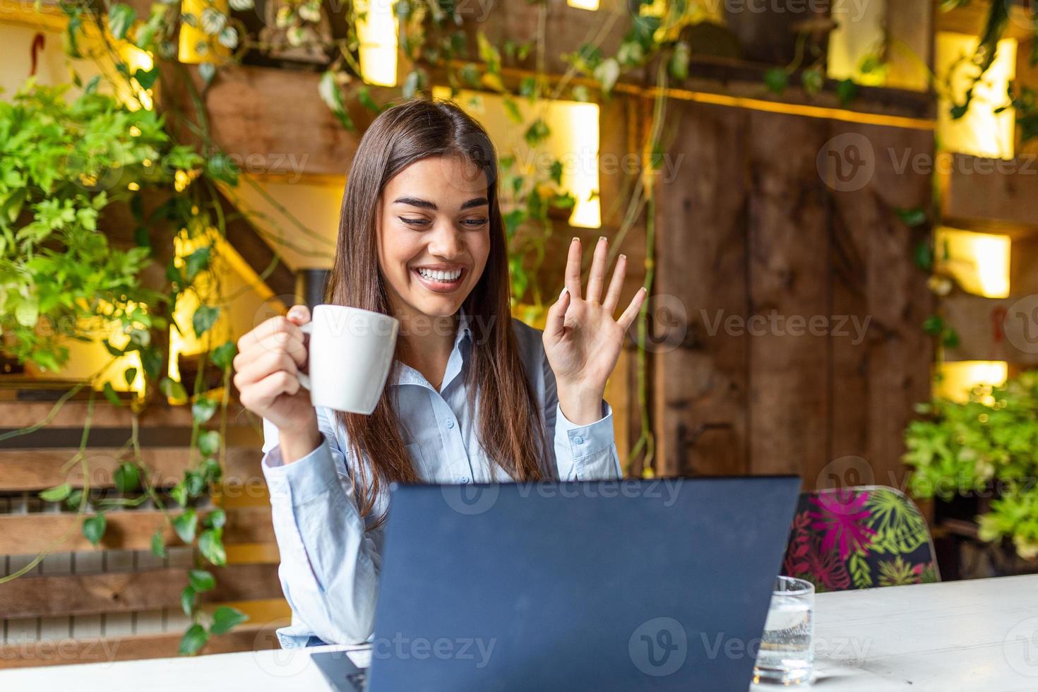 garota no restaurante fala em videochamada acenando com amigos em quarentena, jovem se diverte bate-papo se comunica online usa conversa de webcam em laptop moderno foto