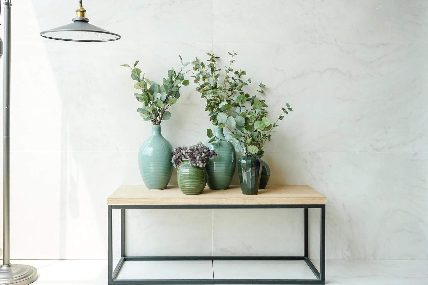 grupo de planta de casa linda com vaso de flores na mesa de madeira e fundo de mármore branco. foto