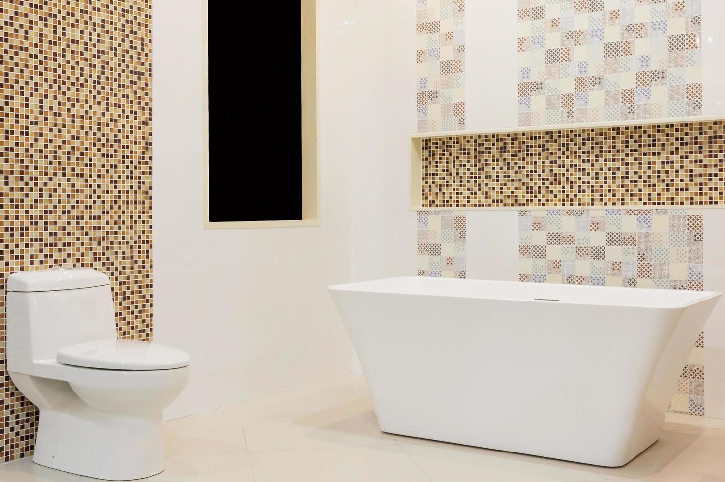 interior luxuoso do banheiro branco com azulejos brancos, espelho, pia e banheira branca. conceito de relaxamento. foto
