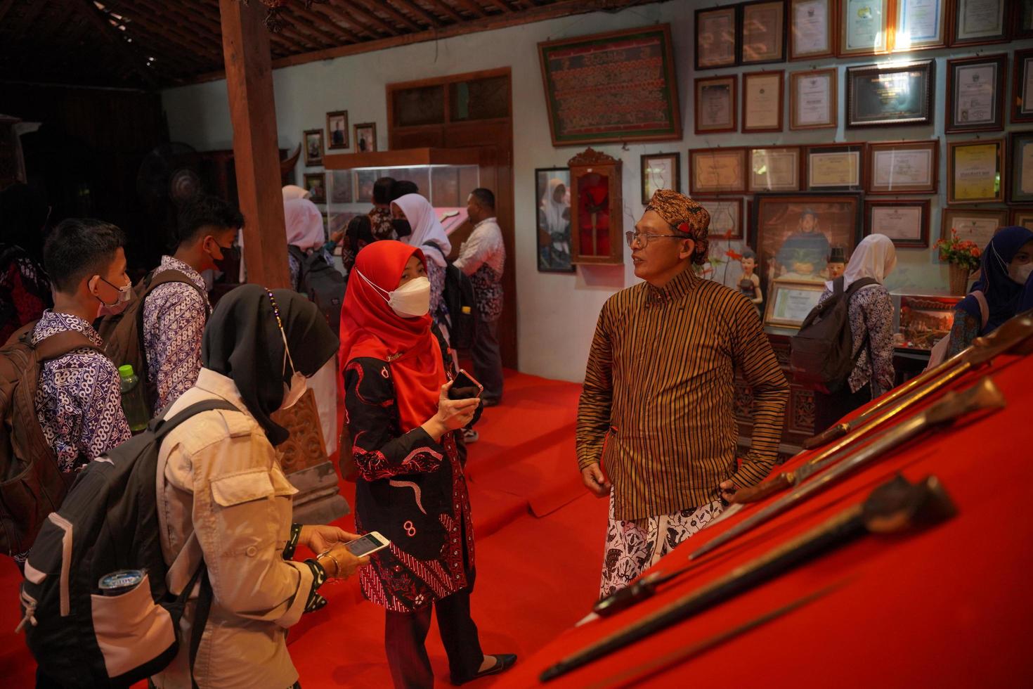 visitantes olhando para uma coleção de kerises em uma galeria. bantul, Indonésia - 25 de agosto de 2022 foto