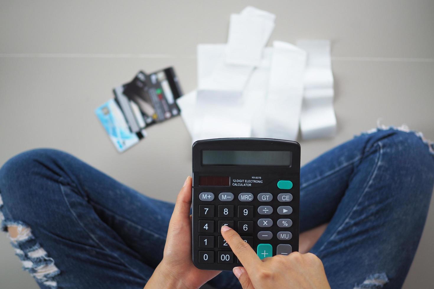 as mulheres sentam-se estressadas com a calculadora calcula as despesas de recebimentos. para pagar a dívida do cartão de crédito. foto