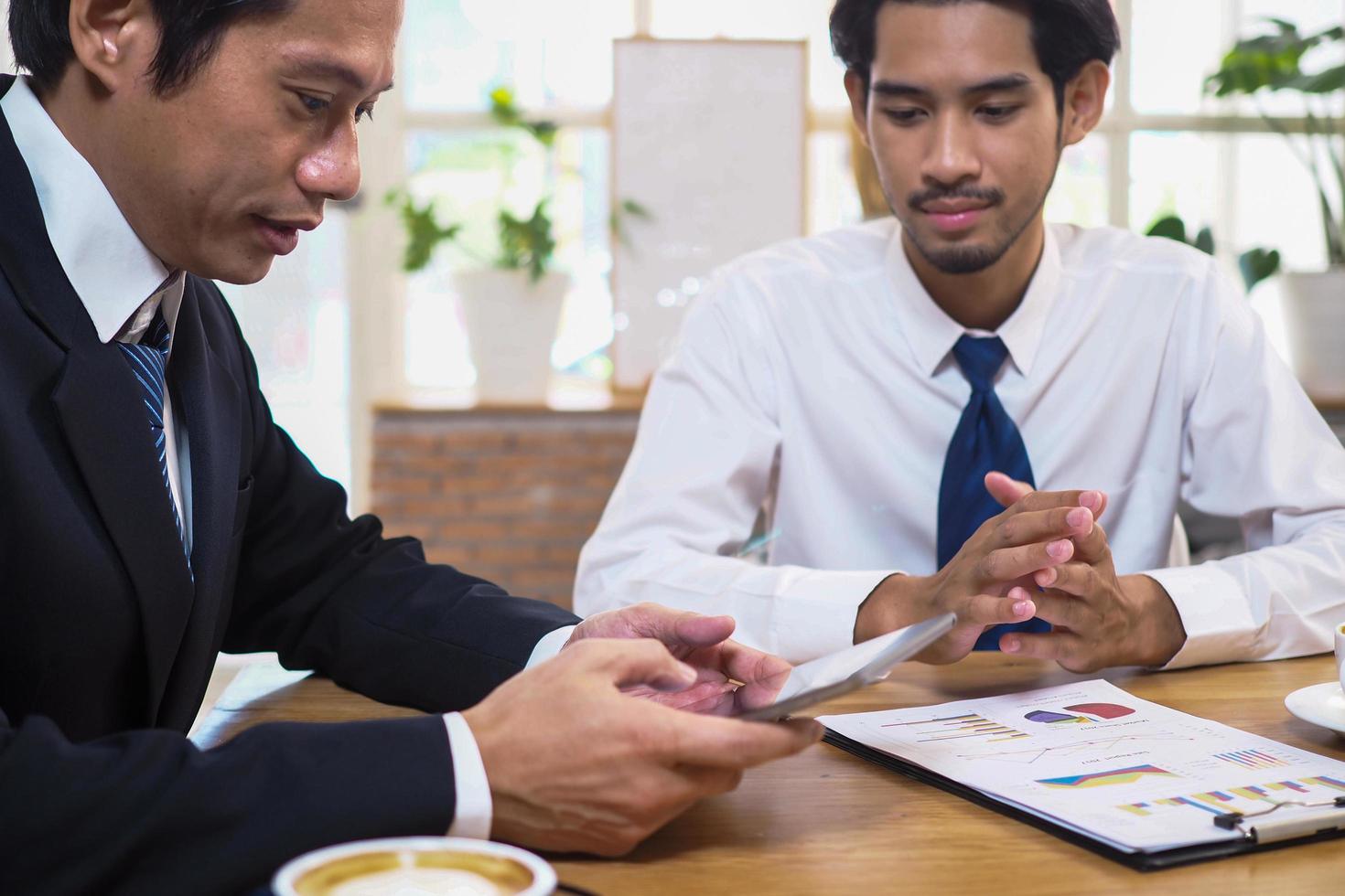 consultores asiáticos analisam e discutem a situação econômica atual. obter aconselhamento financeiro e investir em ações de bancos ou empresas que estão no mercado de ações. foto