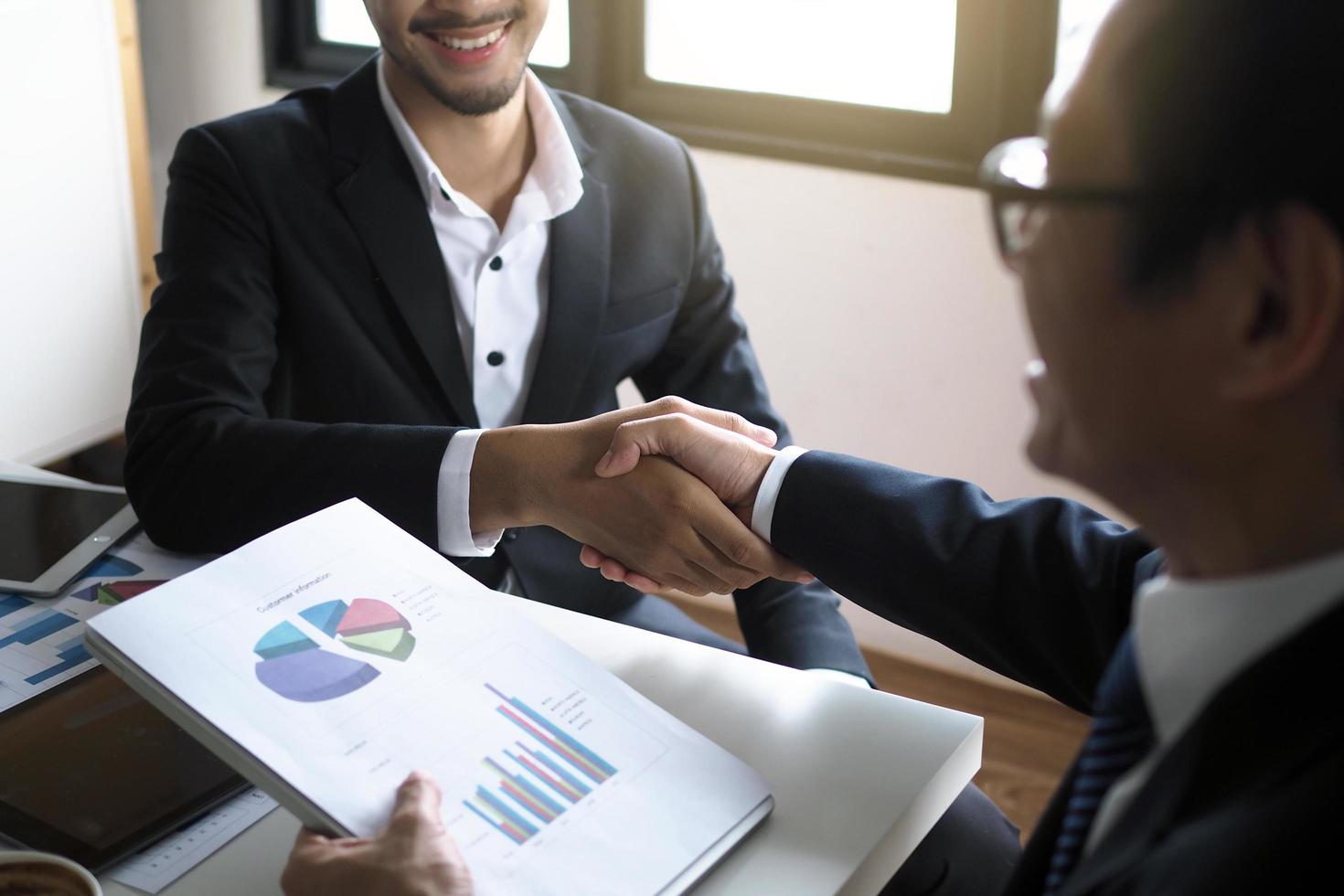 dois empresários apertam a mão para mostrar satisfação nas negociações comerciais. felicidade em trabalhar como parceiro foto