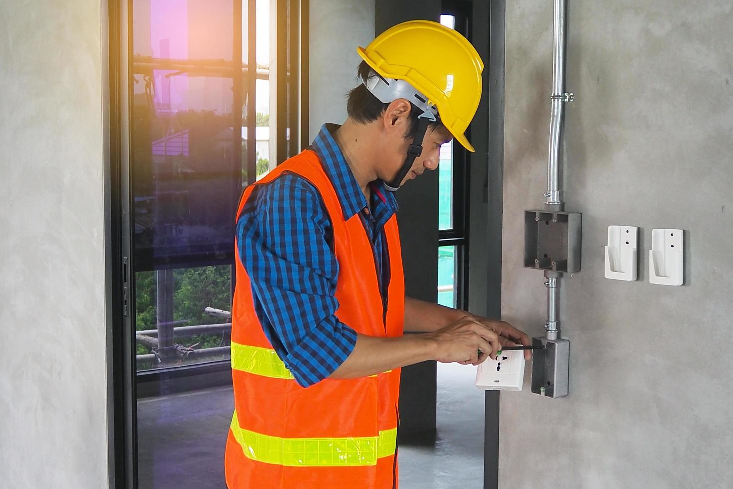 eletricista que trabalha na sala os técnicos de manutenção instalam a fiação em casa. foto