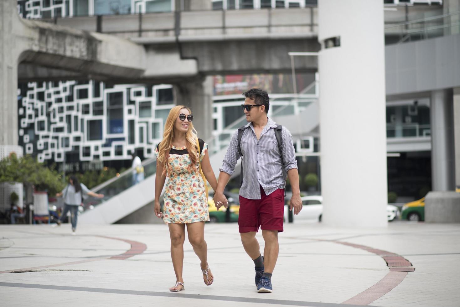 casal feliz caminhando pela cidade juntos foto