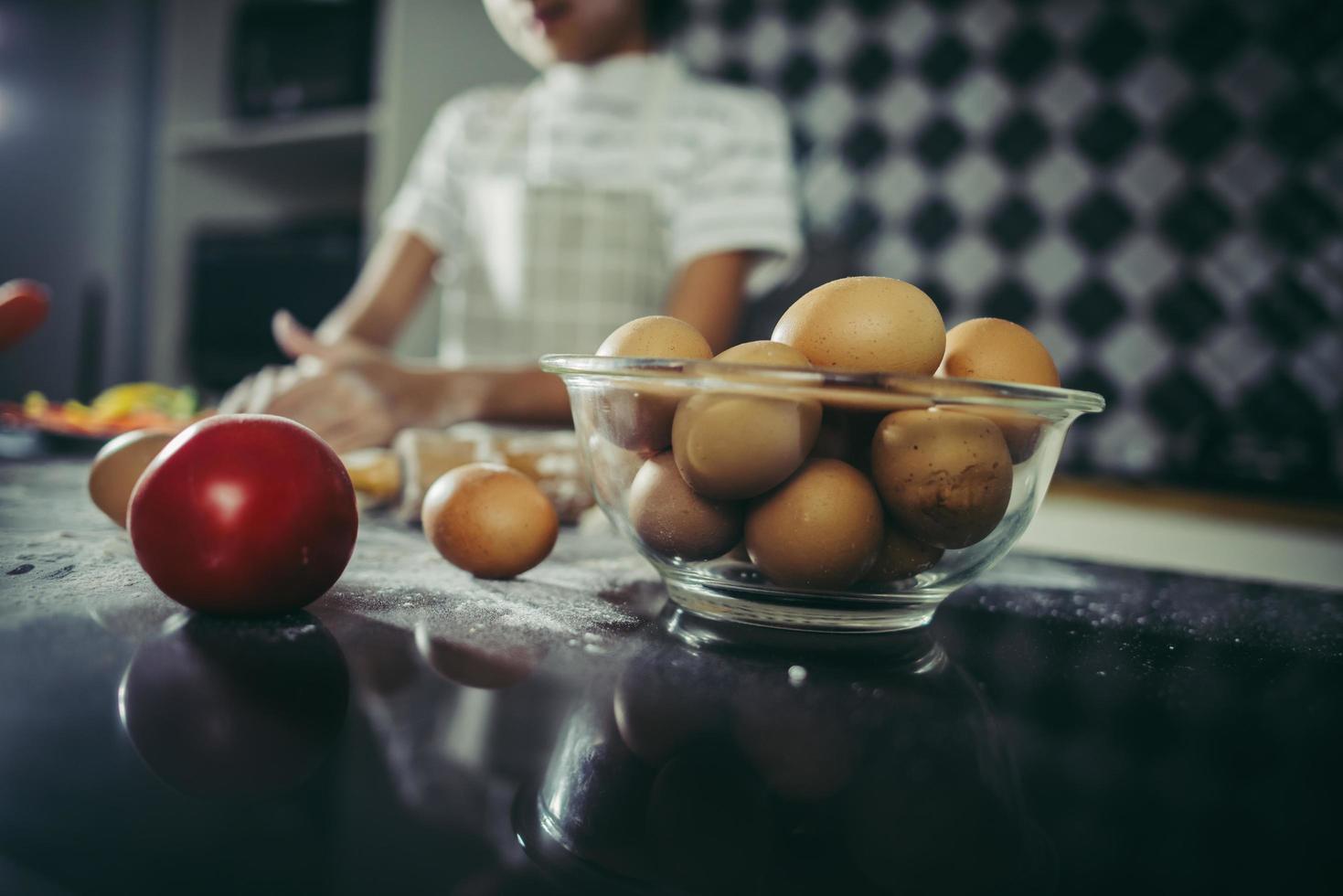 pequeno chef usando rolo para esticar a massa foto