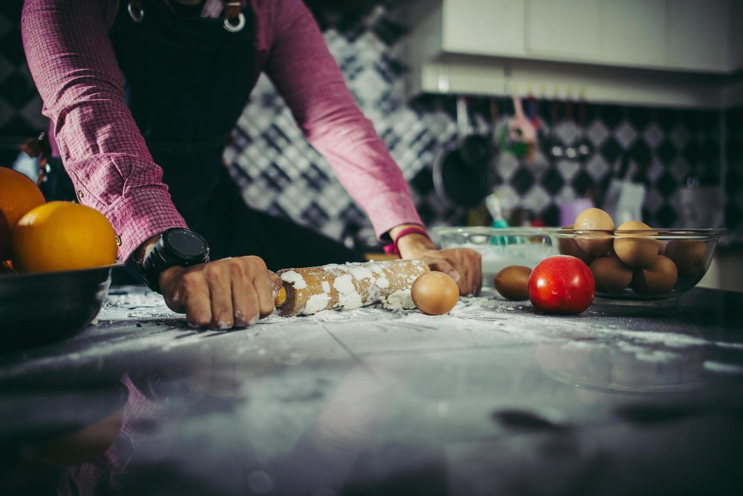 homem amassando massa de pizza caseira na cozinha foto