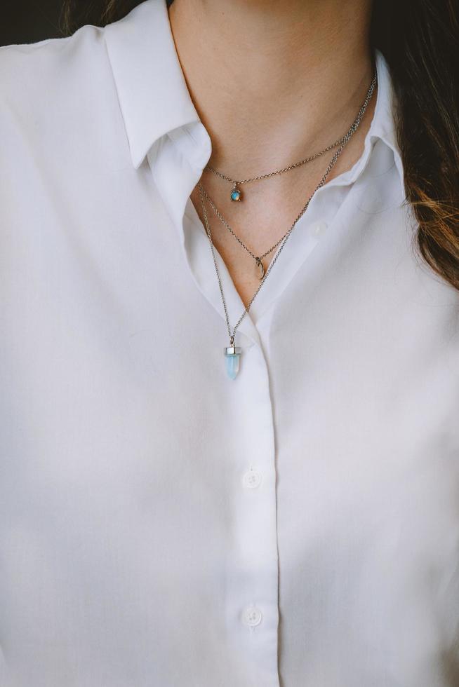 mulher com camisa branca e colar foto