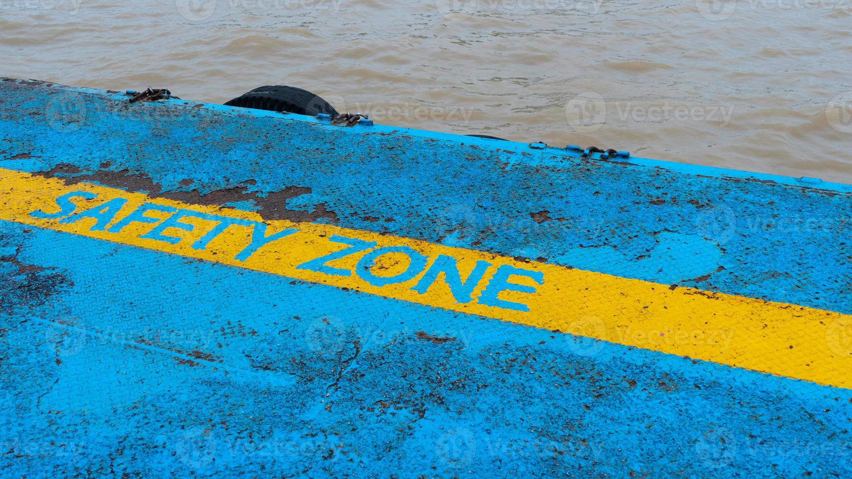 zona de segurança de linha amarela no chão à beira-mar, antigo fundo de metal enferrujado, cais de ferro com textura de metal enferrujado de linha de zona de segurança foto