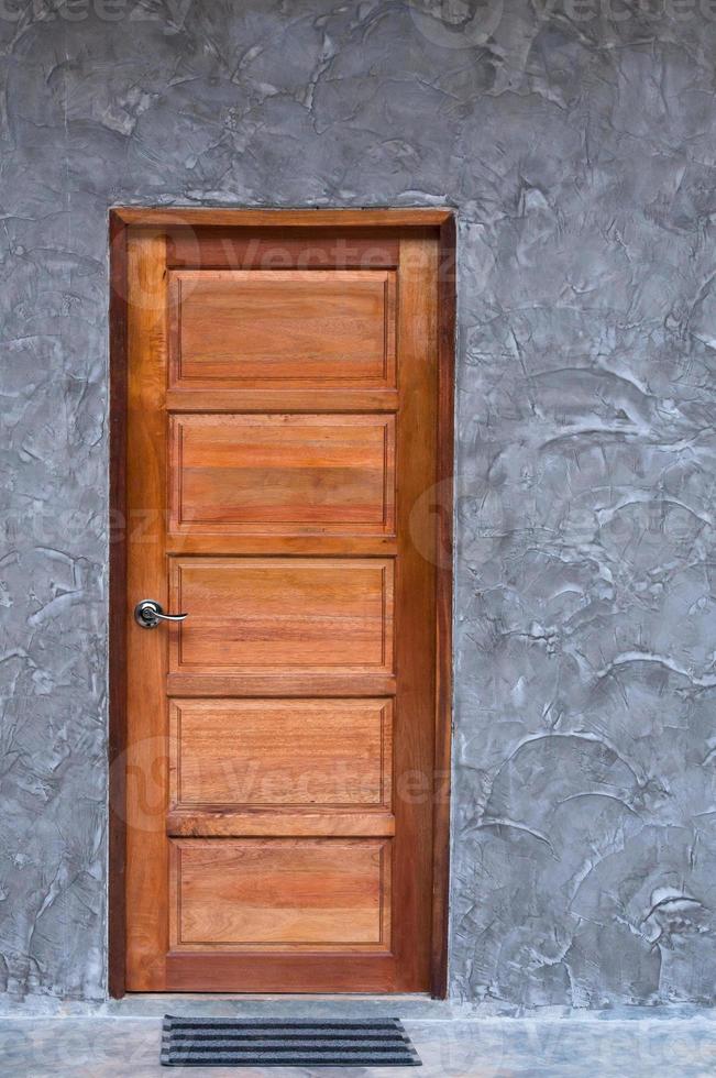 porta de madeira na textura da parede de concreto foto