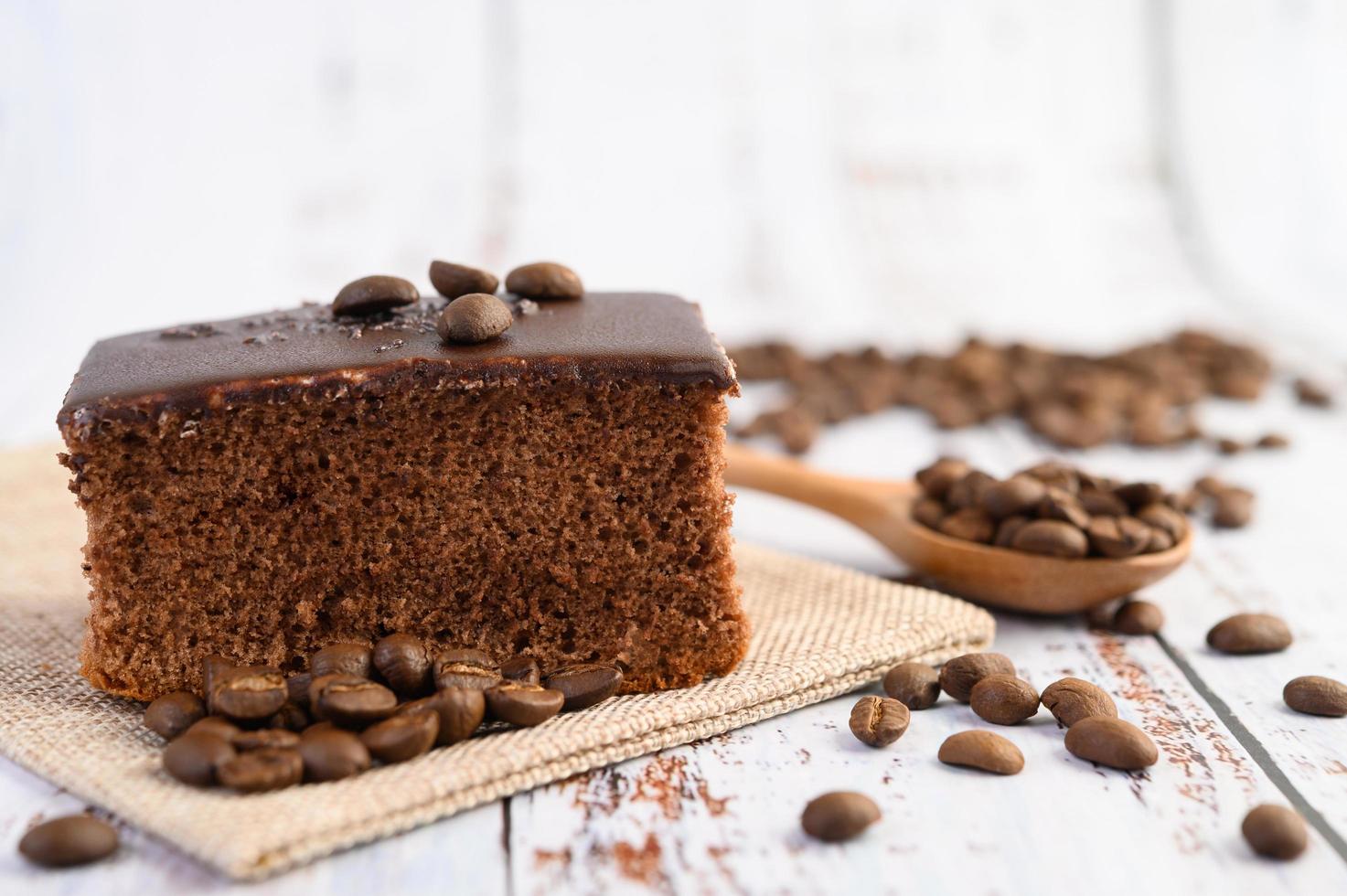 bolo de chocolate com grãos de café em uma mesa de madeira foto