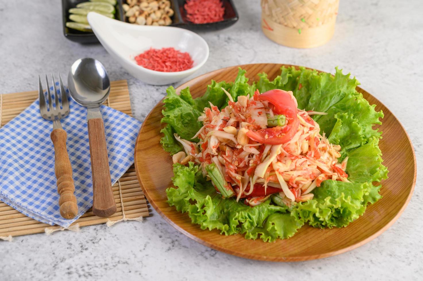 salada tailandesa de mamão com arroz pegajoso, colher e garfo foto