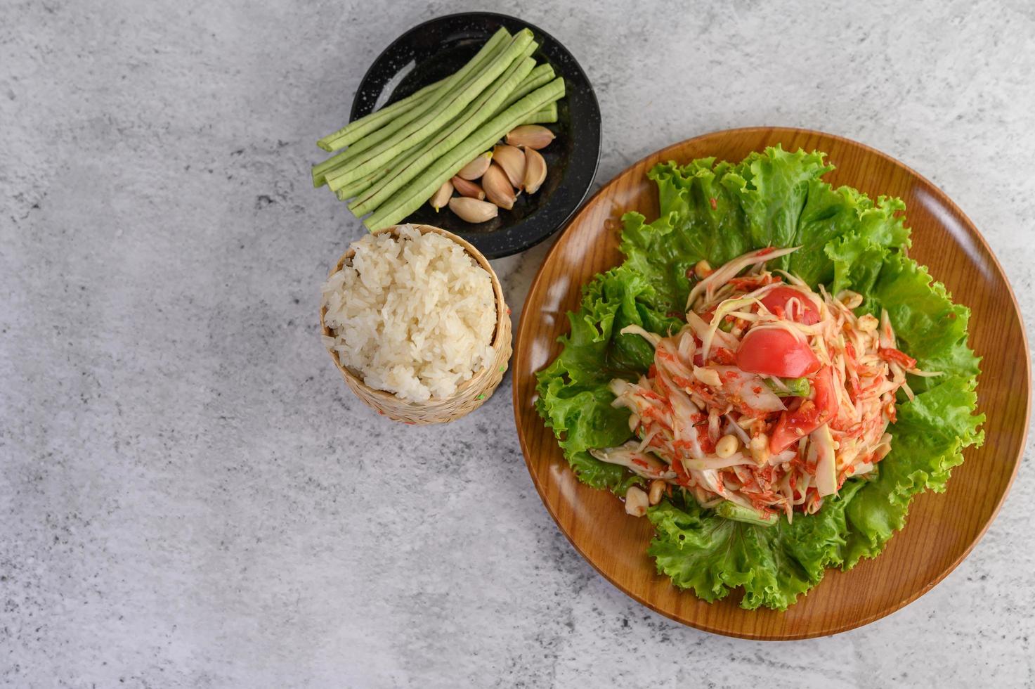 salada tailandesa de mamão com arroz pegajoso foto